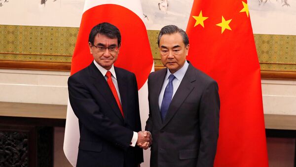 Japanese Foreign Minister Taro Kono, left, and Chinese counterpart Wang Yi pose for photograph before their meeting at the Diaoyutai State Guesthouse in Beijing, China Jan. 28, 2018 - Sputnik International