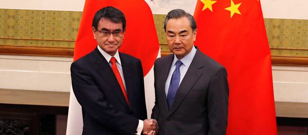 Japanese Foreign Minister Taro Kono, left, and Chinese counterpart Wang Yi pose for photograph before their meeting at the Diaoyutai State Guesthouse in Beijing, China Jan. 28, 2018 Japanese Foreign Minister Taro Kono, left, and Chinese counterpart Wang Yi pose for photograph before their meeting at the Diaoyutai State Guesthouse in Beijing, China Jan. 28, 2018 - Sputnik International