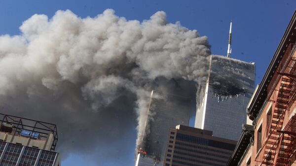 This Sept. 11, 2001 file photo shows smoke rising from the burning twin towers of the World Trade Center after hijacked planes crashed into the towers, in New York City. The U.S. government is aware of no credible or specific information that points to any terror plot tied to the anniversary of the September 2001 attacks, according to a new confidential threat assessment from the FBI and Homeland Security Department obtained by The Associated Press. (AP Photo/Richard Drew, - Sputnik International