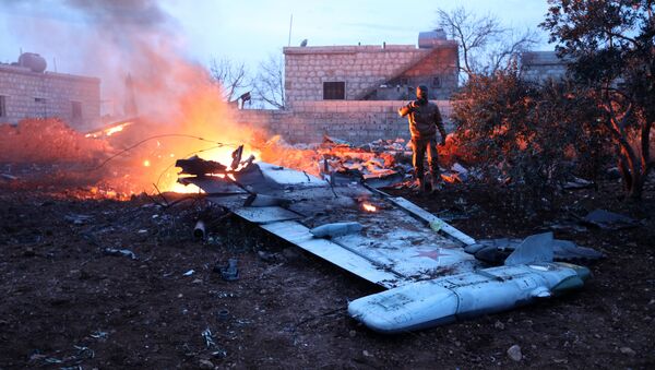 A picture taken on February 3, 2018, shows a Rebel fighter taking a picture of a downed Sukhoi-25 fighter jet in Syria's northwest province of Idlib - Sputnik International