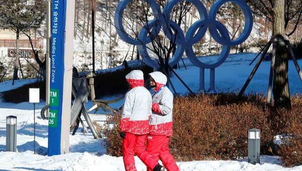 Volunteers walk beside the Olympic rings at the Alpensia resort for the upcoming 2018 Pyeongchang Winter Olympic Games in Pyeongchang, South Korea, January 23, 2018 - Sputnik International