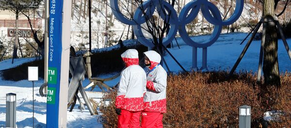 Volunteers walk beside the Olympic rings at the Alpensia resort for the upcoming 2018 Pyeongchang Winter Olympic Games in Pyeongchang, South Korea, January 23, 2018 - Sputnik International