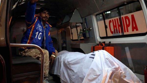 A rescue worker sits in an ambulance with a body of a Chinese man, working with a shipping company in Pakistan, who was shot dead on Monday in what police described as a targeted attack in Karachi, Pakistan February 5, 2018. - Sputnik International