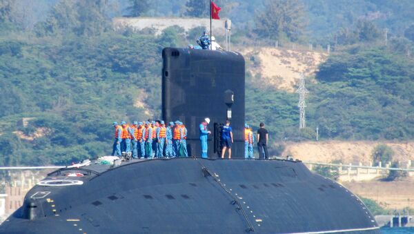 This picture taken on January 3, 2014 shows the Vietnamese Navy's first submarine class Kilo 636 (C) named 'Hanoi' being released into the sea from a Netherland's transporting ship Rolldock Sea at Cam Ranh Bay in central Vietnam - Sputnik International
