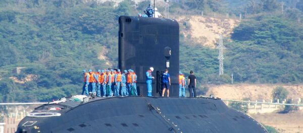 This picture taken on January 3, 2014 shows the Vietnamese Navy's first submarine class Kilo 636 (C) named 'Hanoi' being released into the sea from a Netherland's transporting ship Rolldock Sea at Cam Ranh Bay in central Vietnam - Sputnik International