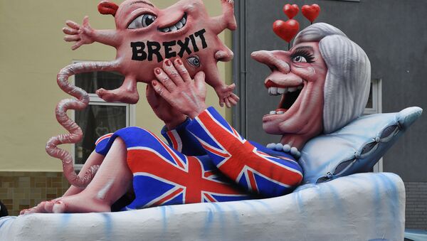 A float depicts British Prime Minister Theresa May looking at her Brexit-baby during the traditional Rose Monday parade in Duesseldorf, Germany - Sputnik International