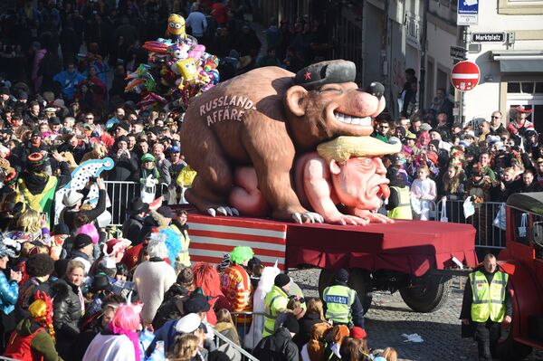 People look at a carnival float, depicting a bear with the writing Russia affair on US President Donald Trump, during a carnival parade on Rose Monday on February 12, 2018 in Duesseldorf, western Germany - Sputnik International