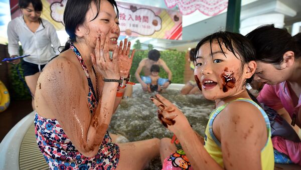 A woman and her daughter put chocolate on their faces as they bath in a 'chocolate spa' at the Hakone Yunessun spa resort facilities in Hakone, Kanagawa prefecture - Sputnik International
