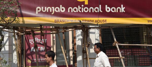 Indian men walk past signage for the state-owned Punjab National Bank (PNB) in Mumbai on February 14, 2018 Indian men walk past signage for the state-owned Punjab National Bank (PNB) in Mumbai on February 14, 2018 - Sputnik International