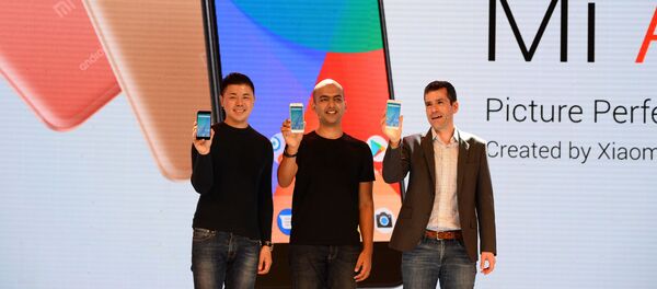 (L-R) Donovan Sung, director of product management and marketing at Xiaomi Global, Manu Jain, managing director of Xiaomi India, and global director of Android Partner Programs Jon Gold hold the newly launched Xiaomi Mi A1 smartphone at a function in New Delhi on September 5, 2017 - Sputnik International