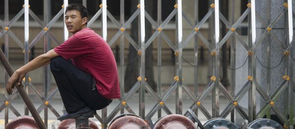 A Chinese man pause as he waits for steel pipes to be loaded onto a truck in Beijing, China. (File) A Chinese man pause as he waits for steel pipes to be loaded onto a truck in Beijing, China. (File) - Sputnik International