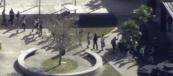In this frame grab from video provided by WPLG-TV, students from the Marjory Stoneman Douglas High School in Parkland, Fla., evacuate the school following a shooting there on Wednesday, Feb. 14, 2018. - Sputnik International