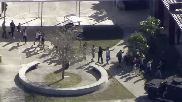 In this frame grab from video provided by WPLG-TV, students from the Marjory Stoneman Douglas High School in Parkland, Fla., evacuate the school following a shooting there on Wednesday, Feb. 14, 2018. - Sputnik International