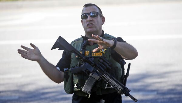 A law enforcement officer tells anxious family members to move back, Wednesday, Feb. 14, 2018, in Parkland, Fla. - Sputnik International