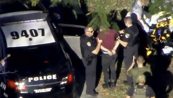 A man placed in handcuffs is led by police near Marjory Stoneman Douglas High School following a shooting incident in Parkland, Florida, U.S. February 14, 2018 in a still image from video - Sputnik International