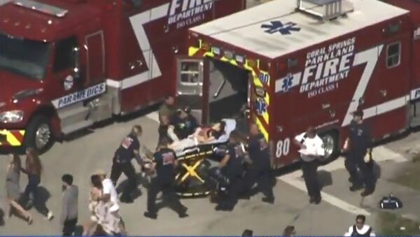 Rescue workers prepare to transport a victim on a stretcher near Marjory Stoneman Douglas High School following a shooting incident in Parkland, Florida, U.S. February 14, 2018 in this still image taken from a video - Sputnik International