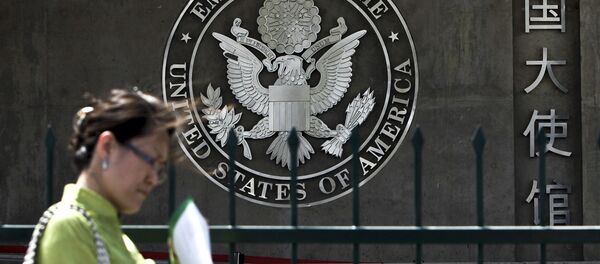 A Chinese woman checks her documents as she walks past the U.S. Embassy in Beijing Friday, May 6, 2011 A Chinese woman checks her documents as she walks past the U.S. Embassy in Beijing Friday, May 6, 2011 - Sputnik International