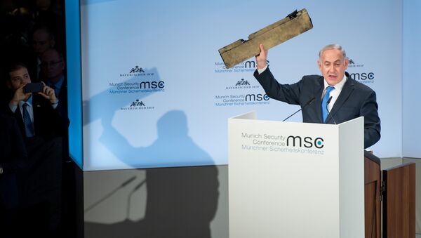 Israeli Prime Minister Benjamin Netanyahu holds up a remnant of what he said was a piece of Iranian drone which was shot down in Israeli airspace during his speech at the Munich Security Conference, Germany February 18, 2018 - Sputnik International