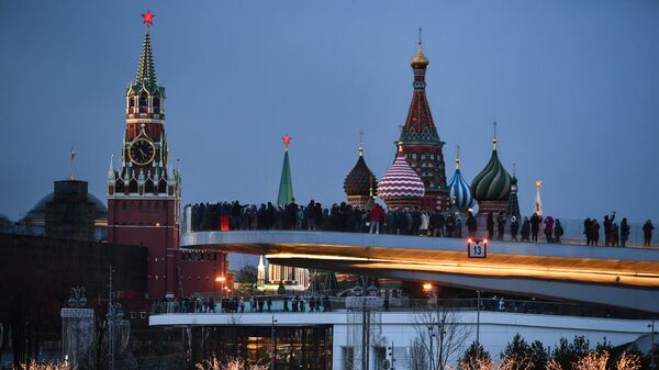 People visit Zaryadye Nature-Landscape Park in Moscow, Russia. Background from left: Spasskaya (Savior) Tower of the Moscow Kremlin and domes of Intercession of the Most Holy Theotokos on the Moat Cathedral (St. Basil's Cathedral) - Sputnik International