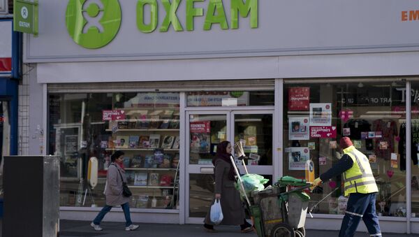 People walk past a high street branch of an Oxfam charity shop in south London - Sputnik International