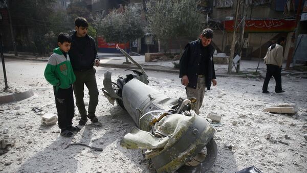 People inspect missile remains in the besieged town of Douma, in eastern Ghouta, in Damascus, Syria, February 23, 2018 - Sputnik International