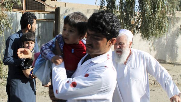 Men carry children away from an explosion site in Lashkar Gah, capital of southern Helmand province, Afghanistan, Saturday, Feb. 24, 2018 - Sputnik International