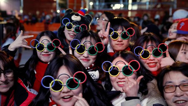 Volunteers wearing Olympic rings shaped sunglasses pose for photographs during a medal ceremony at the Medal Plaza in Pyeongchang, South Korea, February 18, 2018. Picture taken on February 18, 2018 - Sputnik International