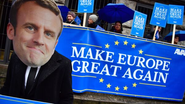 Activists of the Avaaz civic organization wear a mask of French President Emmanuel Macron and hold up posters and a banner reading Make Europe Great Again as they demonstrate on January 11, 2018 in Berlin in front of the venue where are meeting the leaders of Germany's conservative CDU/CSU union and the social democratic SPD party for exploratory talks on forming another governing alliance - Sputnik International