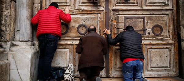 Worshippers kneel and pray in front of the closed doors of the Church of the Holy Sepulchre in Jerusalem's Old City, February 25, 2018 Worshippers kneel and pray in front of the closed doors of the Church of the Holy Sepulchre in Jerusalem's Old City, February 25, 2018 - Sputnik International