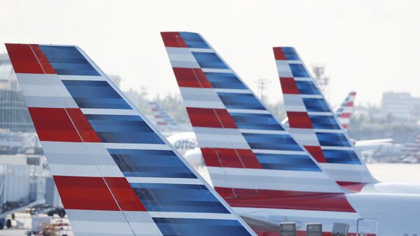 Painted vertical stabilizers are viewed as American Airlines jets are parked on the airport apron, Monday, Nov. 6, 2017, at Miami International Airport in Miami. American Airlines and a subsidiary will pay $9.8 million in stock to settle claims that they failed to help disabled employees return to work. - Sputnik International