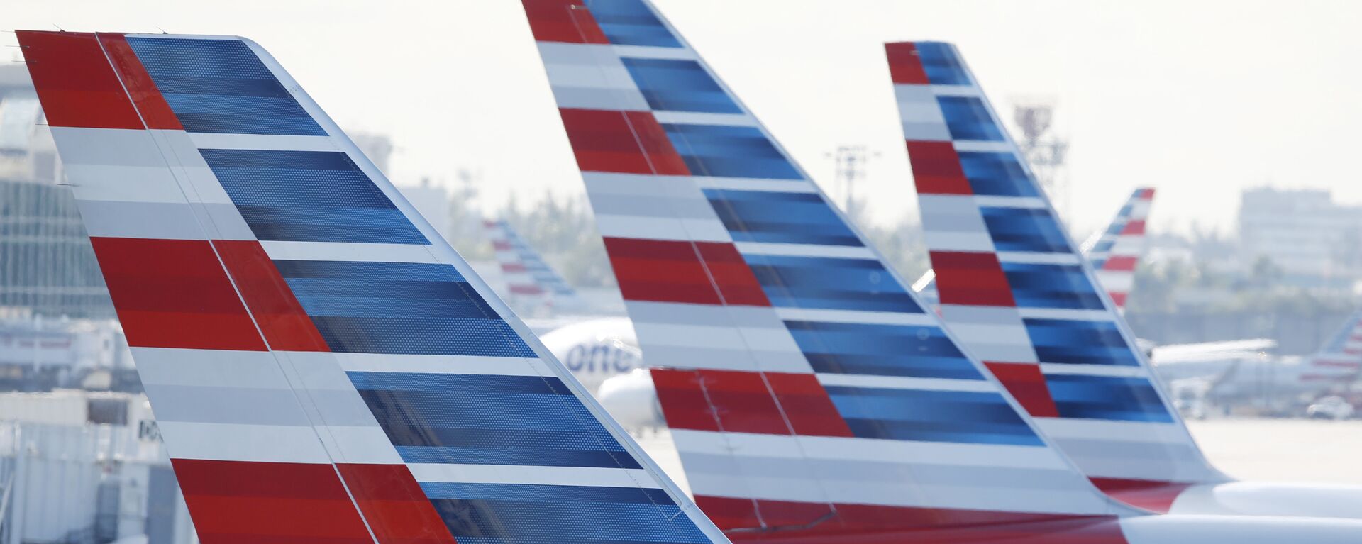 American Airlines tail fins all in a row as the planes are parked on the airport apron on Monday, 6 November 2017, at Miami International Airport in Florida. American Airlines and a subsidiary will pay $9.8 million in stock to settle claims that they failed to help disabled employees return to work. - Sputnik International, 1920, 21.06.2021
