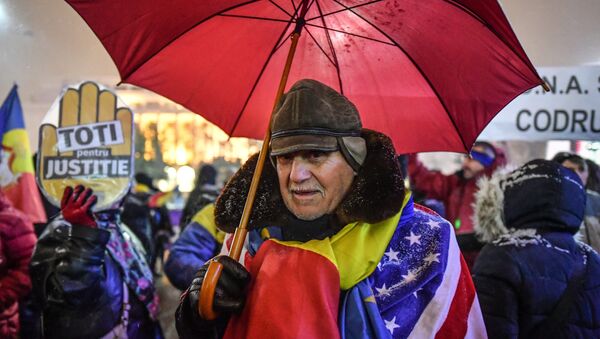 A man wear Romanian and US flags during a protest against the Justice minister and the corruption in front of the Romanian Government in Bucharest - Sputnik International