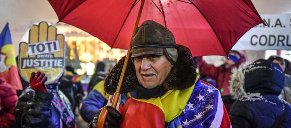 A man wear Romanian and US flags during a protest against the Justice minister and the corruption in front of the Romanian Government in Bucharest - Sputnik International