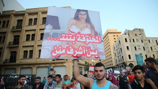 A Lebanese protester raises a poster bearing an image of Lebanese origin Porn Star Mia Khalifa and reading It is true that this woman does sex but she is more decent then them during a mass rally against a political class seen as corrupt and incapable of providing basic services on August 29, 2015 at the iconic Martyrs Square in Beirut - Sputnik International
