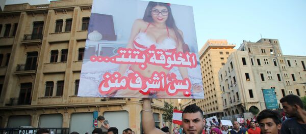 A Lebanese protester raises a poster bearing an image of Lebanese origin Porn Star Mia Khalifa and reading It is true that this woman does sex but she is more decent then them during a mass rally against a political class seen as corrupt and incapable of providing basic services on August 29, 2015 at the iconic Martyrs Square in Beirut A Lebanese protester raises a poster bearing an image of Lebanese origin Porn Star Mia Khalifa and reading It is true that this woman does sex but she is more decent then them during a mass rally against a political class seen as corrupt and incapable of providing basic services on August 29, 2015 at the iconic Martyrs Square in Beirut - Sputnik International