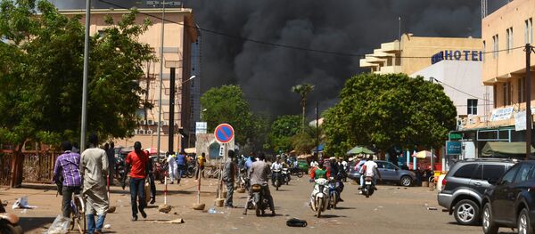 People watch as black smoke rises as the capital of Burkina Faso came under multiple attacks on March 2, 2018, targeting the French embassy, the French cultural centre and the country's military headquarters - Sputnik International