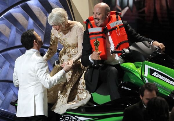 90th Academy Awards - Oscars Show – Hollywood - Best Costume Design winner Mark Bridges rides a jet ski onto the stage as Oscars host Jimmy Kimmel gives actress Helen Mirren on the back a kiss after Bridges won it for the shortest Oscar acceptance speech of 2018 90th Academy Awards - Oscars Show – Hollywood - Best Costume Design winner Mark Bridges rides a jet ski onto the stage as Oscars host Jimmy Kimmel gives actress Helen Mirren on the back a kiss after Bridges won it for the shortest Oscar acceptance speech of 2018 - Sputnik International