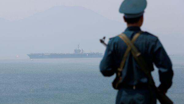 A Vietnamese soldier keeps watch in front of U.S. aircraft carrier USS Carl Vinson after its arrival at a port in Danang, Vietnam March 5, 2018 - Sputnik International