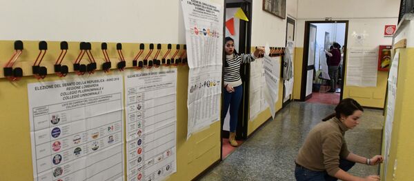 Women post electoral posters at a polling station on March 3, 2018 in Milan - Sputnik International