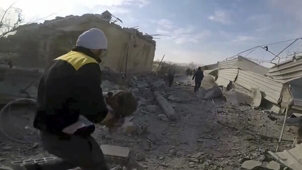 This frame grab from video released on Thursday, March. 1, 2018 by the Syrian Civil Defense White Helmets, which has been authenticated based on its contents and other AP reporting, shows a member of the Syrian Civil Defense group running as he holds a child who was wounded during airstrikes and shelling by Syrian government forces in the eastern Ghouta region near Damascus, Syria - Sputnik International