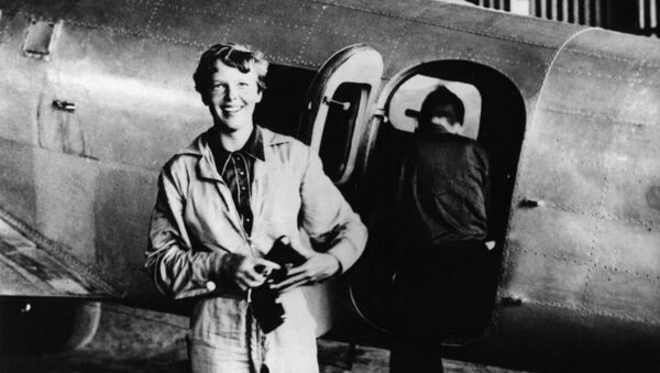 Amelia Earhart standing by her Lockheed Electra with Fred Noonan in the background - Sputnik International