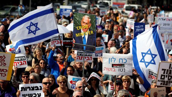 Protesters hold signs calling upon Israeli Prime Minister Benjamin Netanyahu to step down during a rally in Tel Aviv, Israel February 16, 2018 - Sputnik International