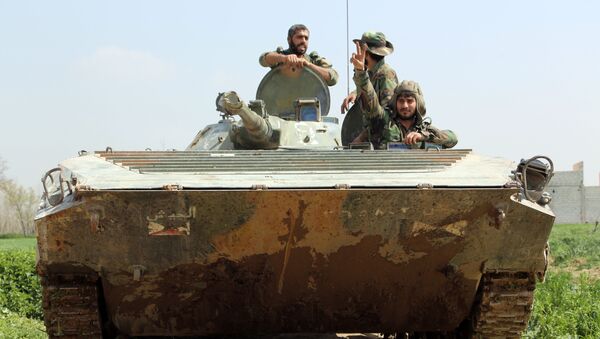 Syrian regime forces sit inside a tank in the town of Aftris, west of the rebel-held town of Saqba, in the besieged Eastern Ghouta region on the outskirts of the capital Damascus, on March 10, 2018 - Sputnik International