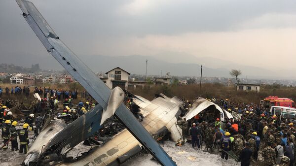 Nepalese rescuers stand near a passenger plane from Bangladesh that crashed at the airport in Kathmandu, Nepal, Monday, March 12, 2018 - Sputnik International