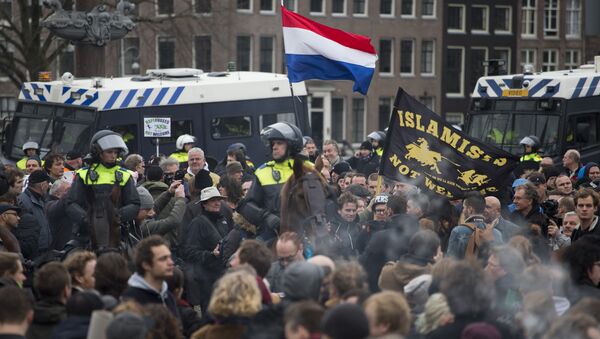 (File) A flag reads Islamists Not Welcome as mounted Dutch riot police separates pro and anti Pegida demonstrators during a rally against islamisation in Amsterdam, Netherlands, Saturday, Feb. 6, 2016 - Sputnik International