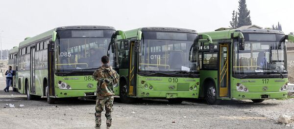 A picture taken on March 13, 2018 shows buses waiting to evacuate civilians on the government side of the Wafideen checkpoint on the outskirts of the Syrian capital Damascus neighbouring the Eastern Ghouta enclave A picture taken on March 13, 2018 shows buses waiting to evacuate civilians on the government side of the Wafideen checkpoint on the outskirts of the Syrian capital Damascus neighbouring the Eastern Ghouta enclave - Sputnik International