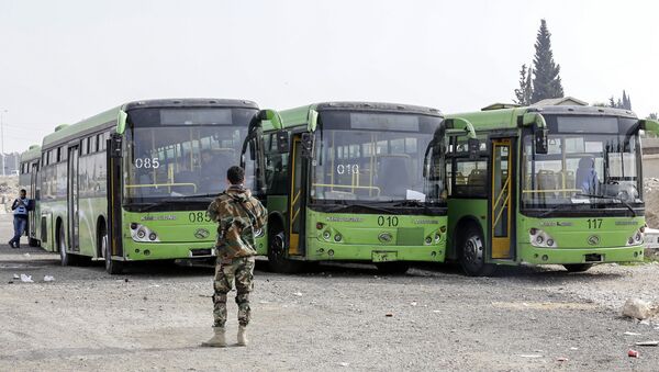 A picture taken on March 13, 2018 shows buses waiting to evacuate civilians on the government side of the Wafideen checkpoint on the outskirts of the Syrian capital Damascus neighbouring the Eastern Ghouta enclave - Sputnik International