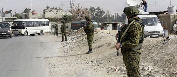 Russian military police members stand guard at the Wafideen checkpoint on the outskirts of the Syrian capital Damascus neighbouring the rebel-held Eastern Ghouta enclave on March 13, 2018, awaiting any civilians evacuating from the area Russian military police members stand guard at the Wafideen checkpoint on the outskirts of the Syrian capital Damascus neighbouring the rebel-held Eastern Ghouta enclave on March 13, 2018, awaiting any civilians evacuating from the area - Sputnik International