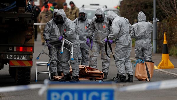 British Military personnel wearing protective coveralls work to remove a vehicle connected to the March 4 nerve agent attack in Salisbury, from a residential street in Gillingham, southeast England on March 14, 2018 - Sputnik International