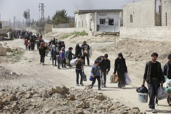 Syrians civilians evacuated from the Eastern Ghouta enclave pass with belongings through the regime-controlled corridor opened by government forces in Hawsh al-Ashaari, east of the enclave town of Hamouria on the outskirts of the capital Damascus on March 15, 2018 Syrians civilians evacuated from the Eastern Ghouta enclave pass with belongings through the regime-controlled corridor opened by government forces in Hawsh al-Ashaari, east of the enclave town of Hamouria on the outskirts of the capital Damascus on March 15, 2018 - Sputnik International